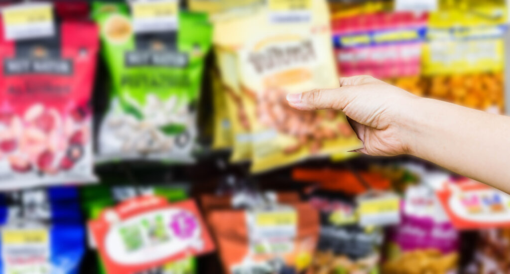 コンビニのお菓子を手に取る人